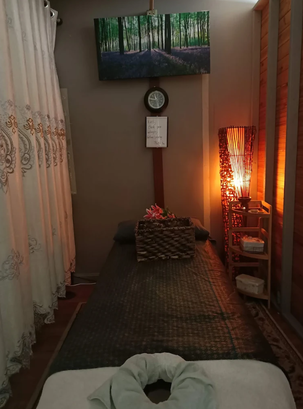 Cozy massage room with warm lighting and bamboo lamp